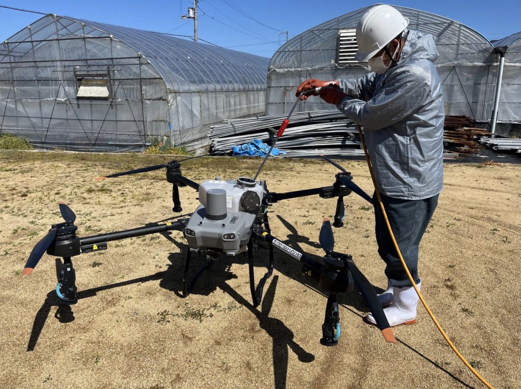 農業用ハウスへの散布作業に向けてT25を準備する作業者